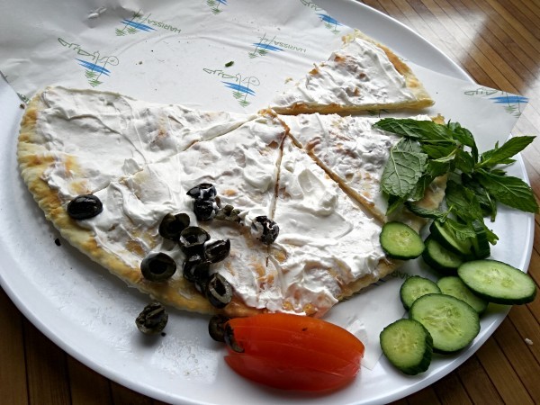Manouche with labneh accompanied by greens and fresh peppermint leaves Manouche with labneh accompanied by greens and fresh peppermint leaves
