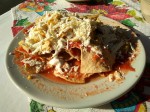 Chilaquiles rojos con pollo, crema y queso fresco. Traditional chilaquiles in red salsa, serverd with pulled chicken, cream and fresh cheese.
