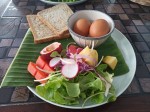 Hard boiled eggs with toasts, vegetables and fruits