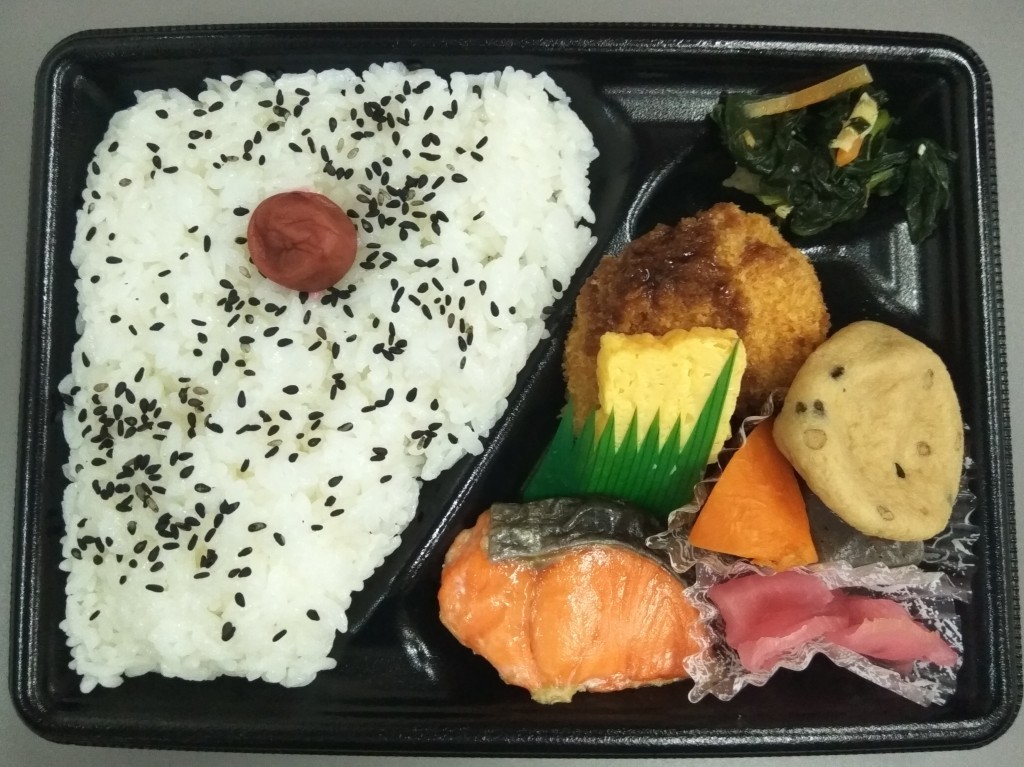A lunch box with rice decorated with umeboshi.