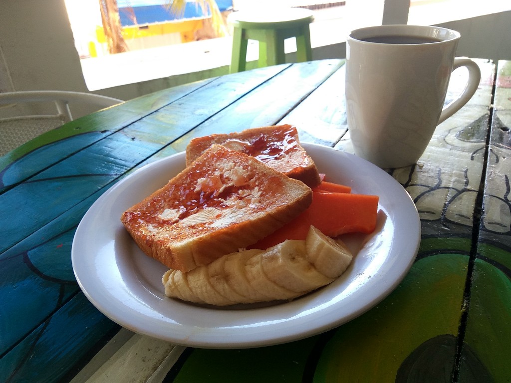 A Mexican breakfast in a hostel. Toasted bread with jam and fruits - banana and papaya - Playa del Carmen, Guacamole guesthouse.