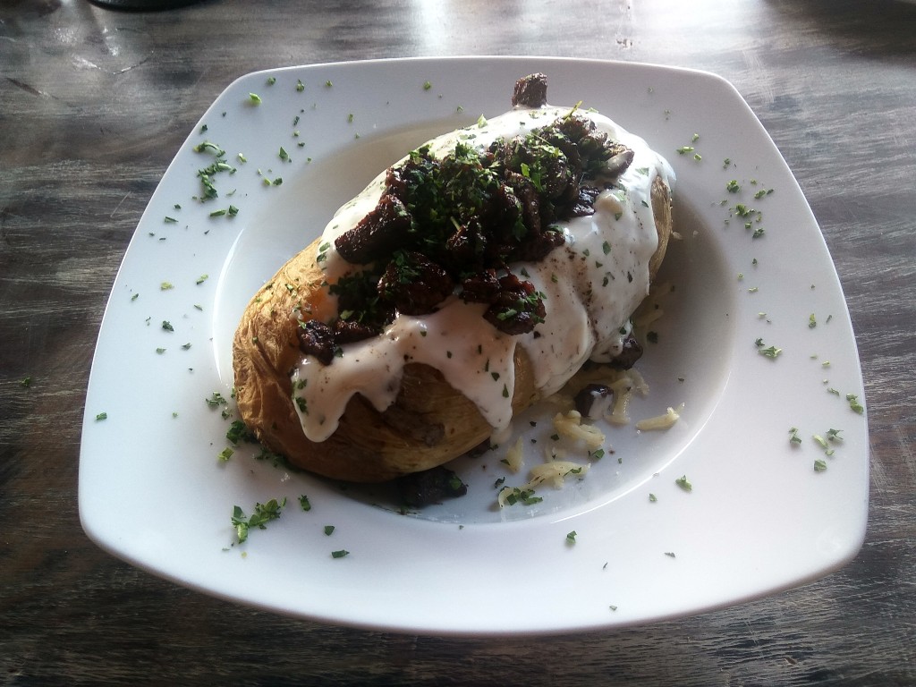 Papa al horno relleno con queso, carne y crema.