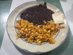 Huevos revueltos con tocino - scrambled eggs with bacon, served with fried black beans and a slice of cheese. Huevos revueltos con tocino - scrambled eggs with bacon, served with fried black beans and a slice of cheese.
