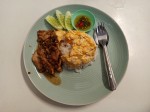 Omelet on rice with fried pork and garlic served with chilis in a fish sauce