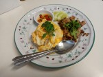 Omelet on rice with fried pork and garlic served with chilis in a fish sauce