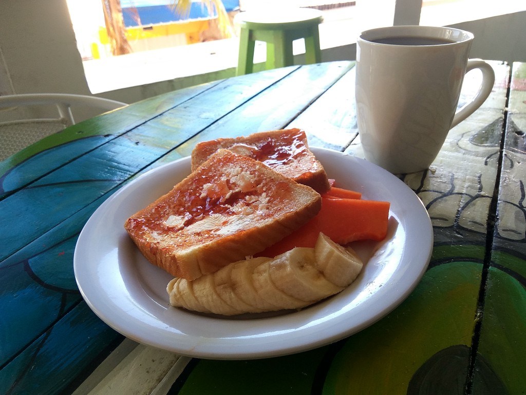 A Mexican breakfast in a hostel. Toasted bread with jam and fruits - banana and papaya - Playa del Carmen, Guacamole guesthouse. A Mexican breakfast in a hostel. Toasted bread with jam and fruits - banana and papaya - Playa del Carmen, Guacamole guesthouse.