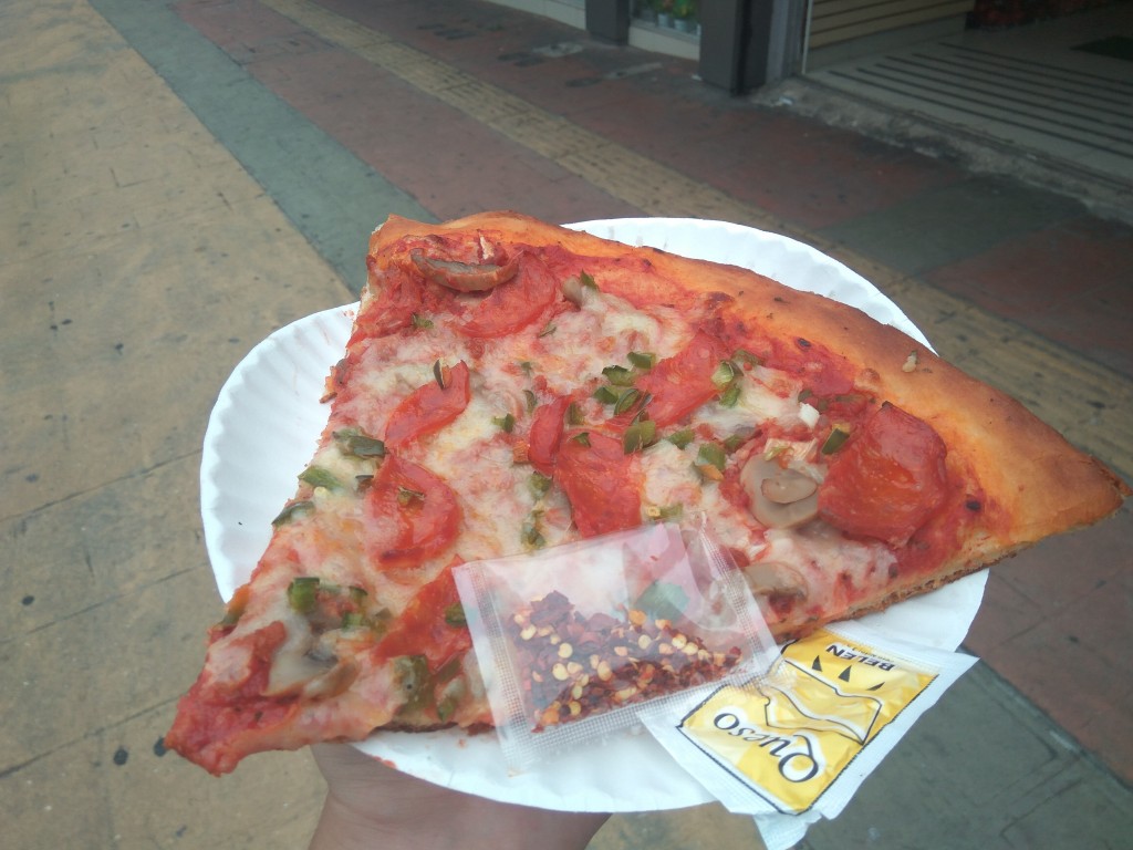 While waiting for a bus, have your own pizza slice bought in the morning