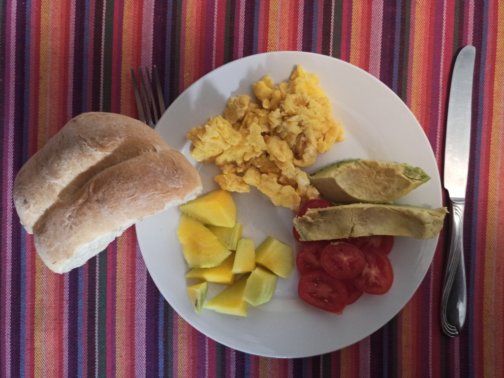Semi-traditional Guatemalan breakfast – fried beans with scrambled eggs bread and fruits like papaya, mango, pineapple or watermelon