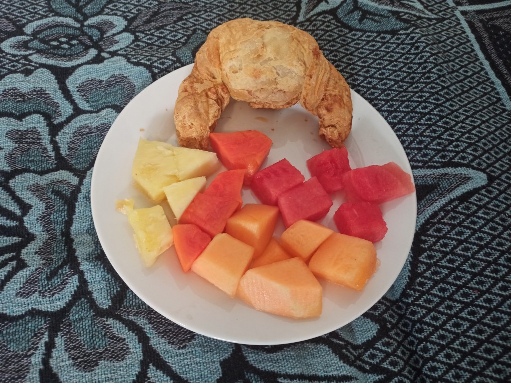 Continental breakfast – croissant with fresh, juicy fruits – melon, watermelon, papaya and pineapple